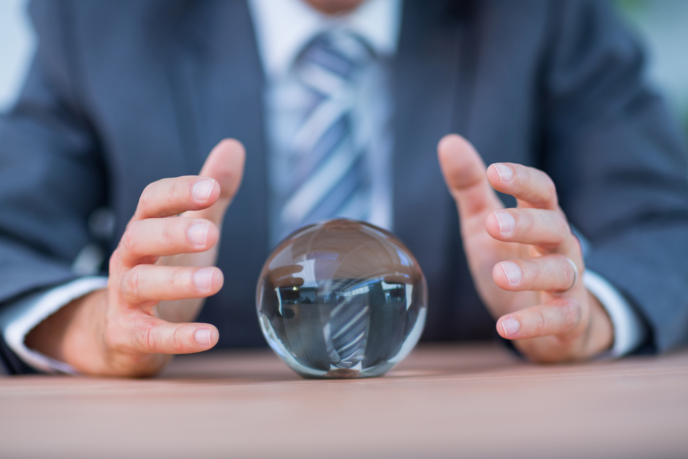 Business man holding his hands over a crystal ball